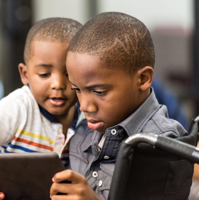 2 children using a tablet